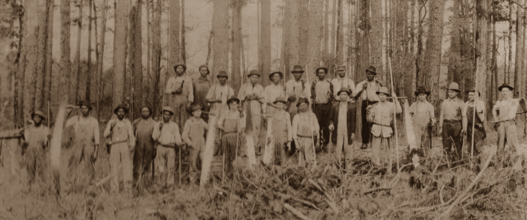 Black and white loggers pose side by side for a photo in Maxville, OR.