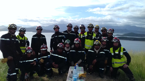 Group photo of Romain and his trainees posing in front of a body of water.